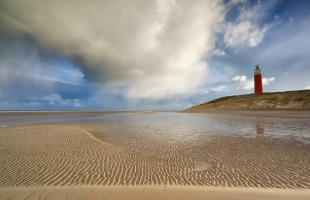 shower cloud over coast with red lighthouse, texel, holland - nodoby imagens e fotografias de stock