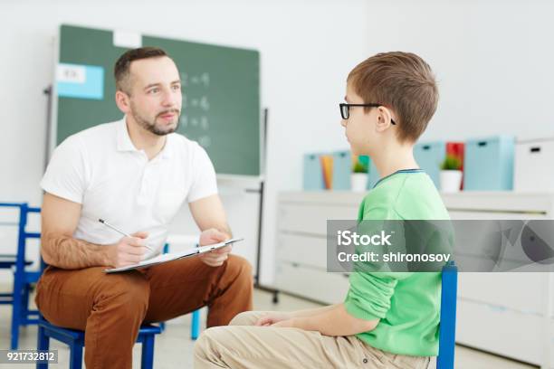 Profesor Y Niño En Edad Escolar Foto de stock y más banco de imágenes de Profesional de salud mental - Profesional de salud mental, Niño, Educación