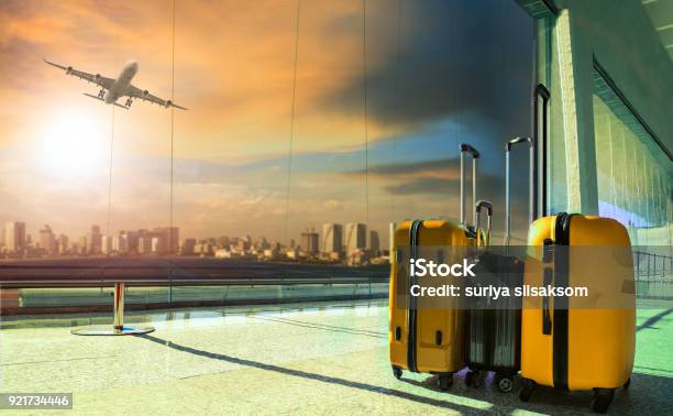 Traveling Luggage In Airport Terminal Building With Passenger Plane Flying Over Runway Stock Photo - Download Image Now