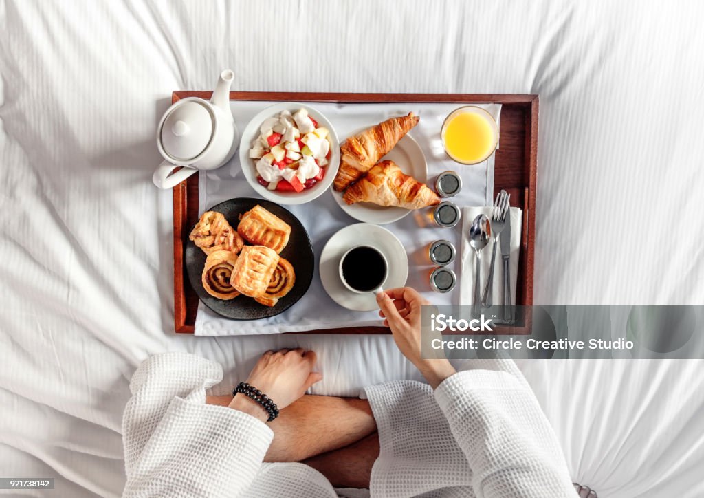 Breakfast in bed A Man Having Breakfast on a bed in a Hotel Room. Flat lay Breakfast Stock Photo