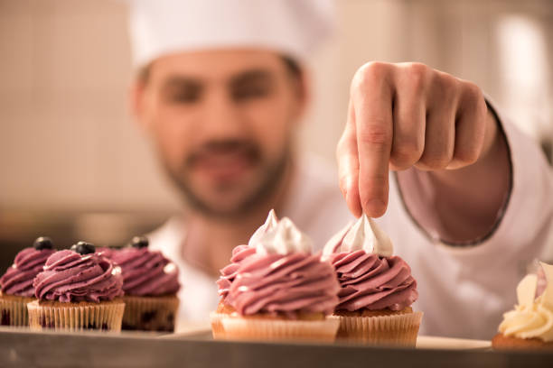 istock selective focus of confectioner decorating cupcakes in restaurant kitchen 921780890