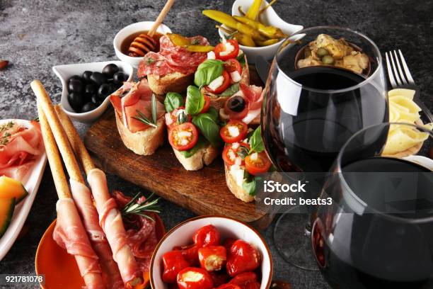 Italian Antipasti Wine Snacks Set Cheese Variety Mediterranean Olives Pickles Prosciutto Di Parma Tomatoes Artichokes And Wine In Glasses Stock Photo - Download Image Now