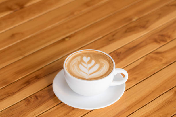 istock Hot Coffee latte art cappuccino White cup on Wooden table 921787708