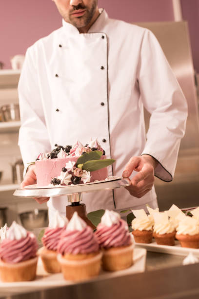 istock partial view of confectioner holding cake in restaurant kitchen 921787866