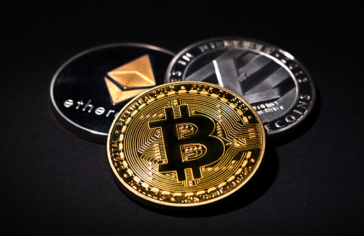 İstanbul, Turkey - February 19, 2018: Close up shot of Bitcoin, Litecoin and Ethereum memorial coins on a black background. Bitcoin, Litecoin and Ethereum are crypto currencies and worldwide payment systems.