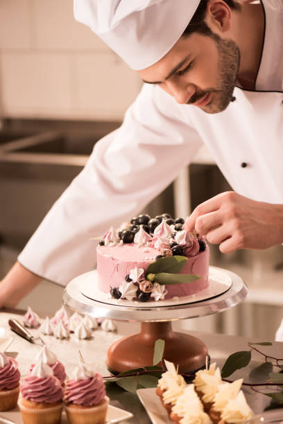 istock portrait of confectioner decorating cake in restaurant kitchen 921788806