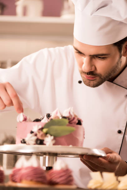 istock portrait of confectioner decorating cake in restaurant kitchen 921788896