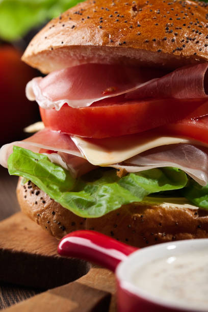 istock Delicious sandwich with prosciutto ham, cheese and vegetables 921789210