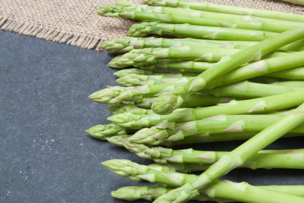istock bunch of asparagus on sack over slate  background 921789630