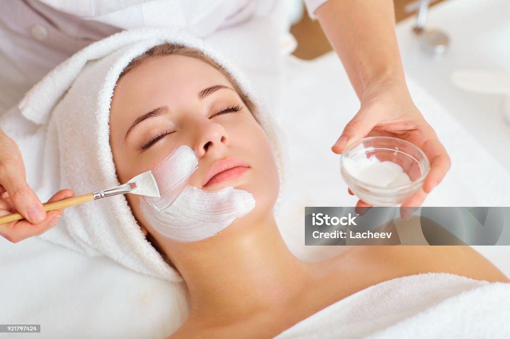 Donna in maschera sul viso in salone di bellezza spa - Foto stock royalty-free di Maschera per il viso