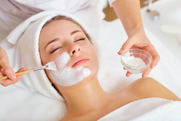 donna in maschera sul viso in salone di bellezza spa - trattamento di benessere foto e immagini stock