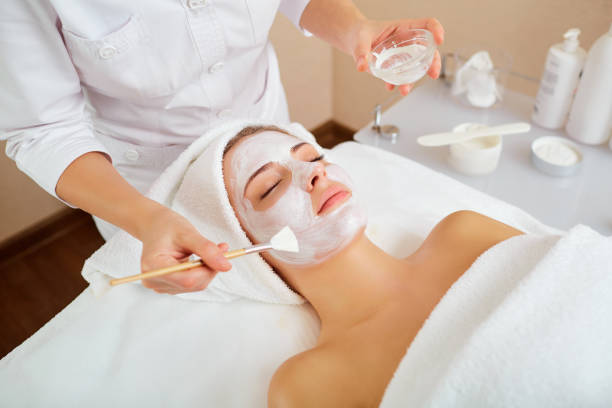 женщина в маске на лице в спа салоне красоты - mud wellbeing spa treatment beautician стоковые фото и изображения