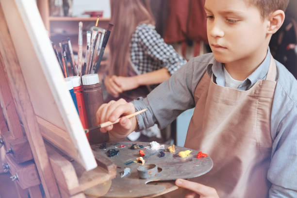 istock Focused youngster painting on art canvas in studio 921802066