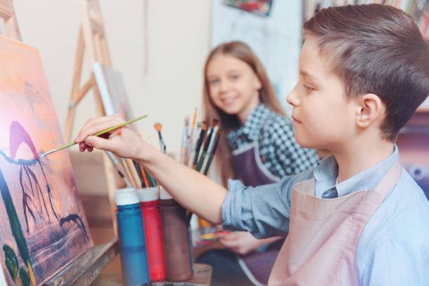 istock Cheerful kids painting together 921803652