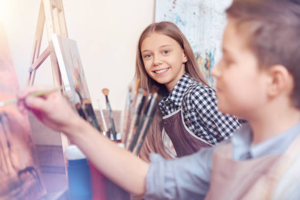 istock Smiling children painting on art canvas 921803702