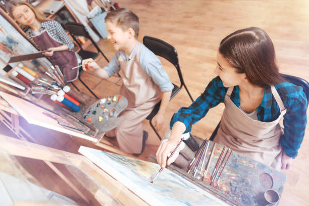 istock Funny children getting excited while painting 921805898