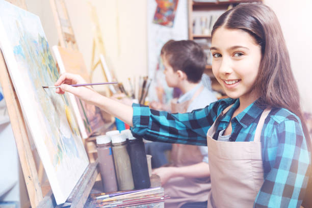 istock Young lady holding painting brush posing for camera 921805946