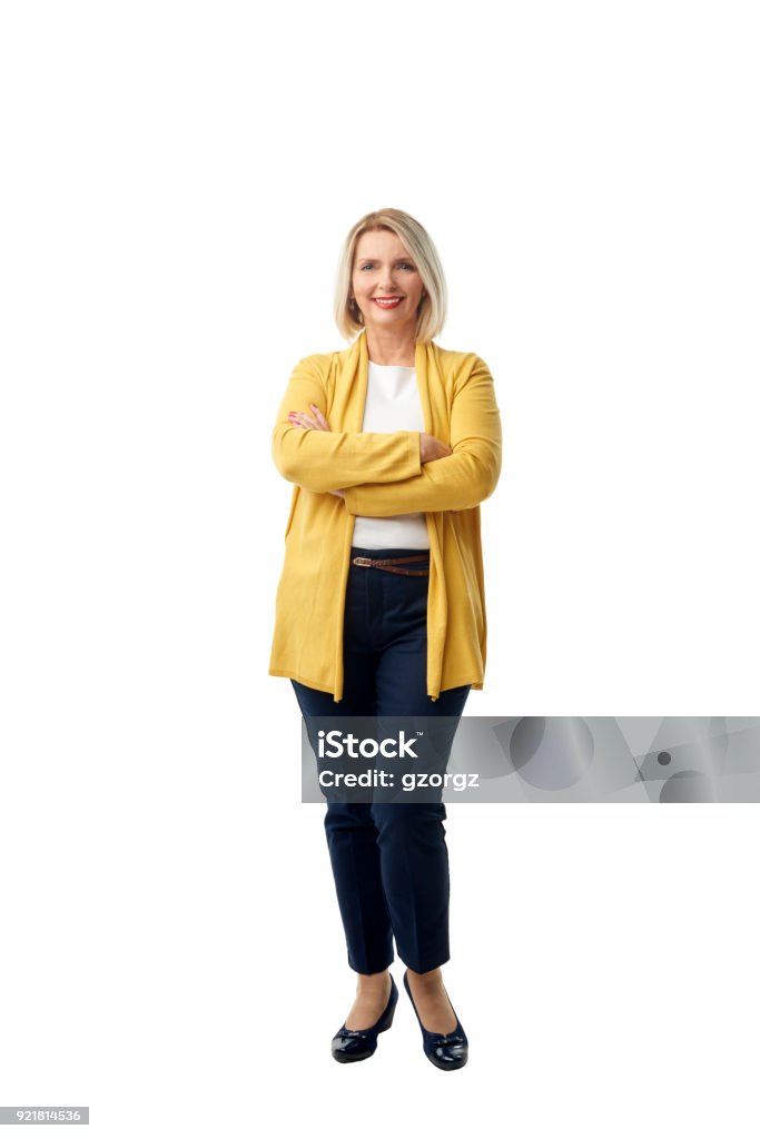 Confident mature woman portrait Full length shot of an attractive mature woman smiling at the camera while standing against at isolated white background. Women Stock Photo