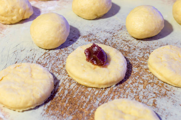istock Adding marmalade to Polish donuts knows as Paczki. 921827972