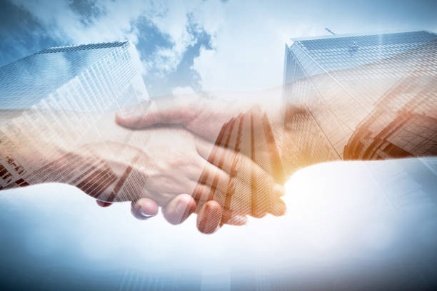istock Business handshake over modern skyscrapers, double exposure. 921828582