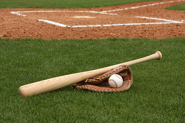 Baseball, bat, and glove on field in front of home plate stock photo