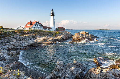 Portland Head lighthouse with the rocky coastline in the foreground. Portland, Maine, United States.