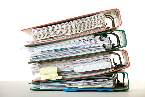 A stack of colorful ring binders full of paperwork stock photo