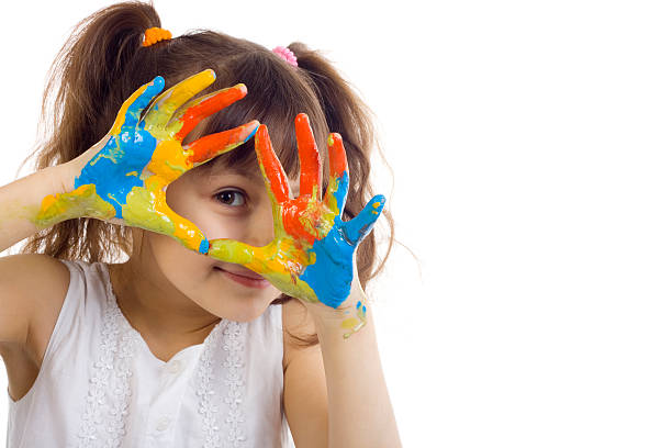 красивая девочка играет с цветами - child multi colored painting art стоковые фото и изображения