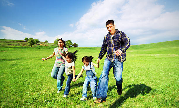 Família feliz a correr no campo - fotografia de stock