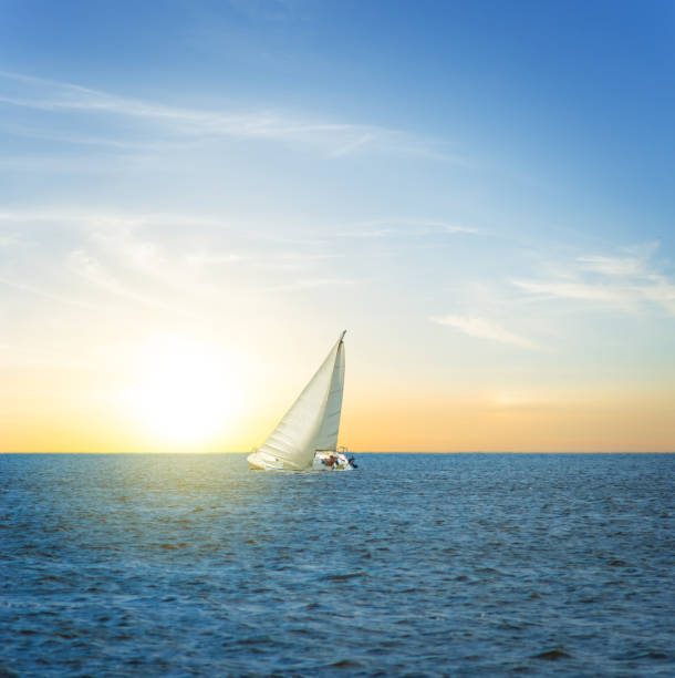 istock white alone sail yacht among a sea at the sunset 921852508