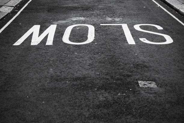 istock Slow, white text road marking over asphalt 921869684