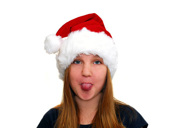 weihnachts-mädchen - making a face mischief sticking out tongue isolated on red stock-fotos und bilder