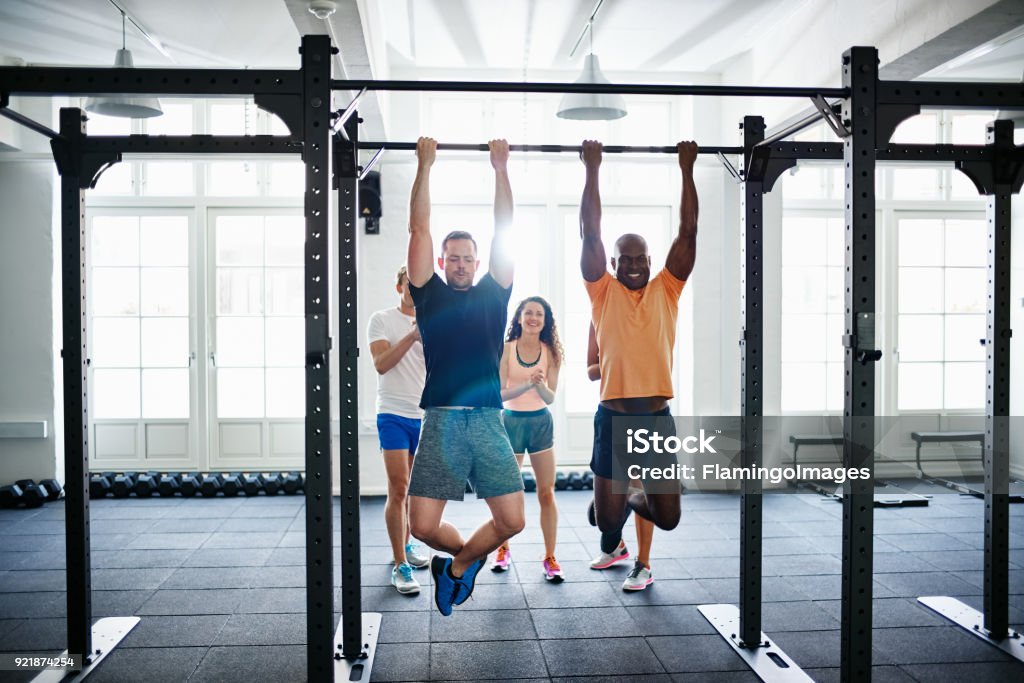 Menschen beobachten zwei Männer tun Chin ups in einem Fitnessstudio - Lizenzfrei Klimmzug Stock-Foto