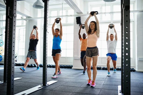 istock Fit people working out with weights in a gym 921878780