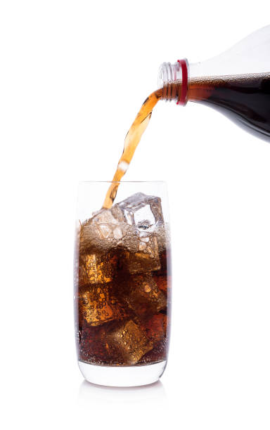 istock Bottle pouring Cola in drink glass with ice cubes 921878808