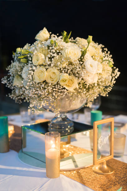 istock White rose bouquet set up on reception night wedding with boken at night. 921879736