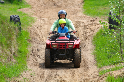 Dad with son riding a quad bike