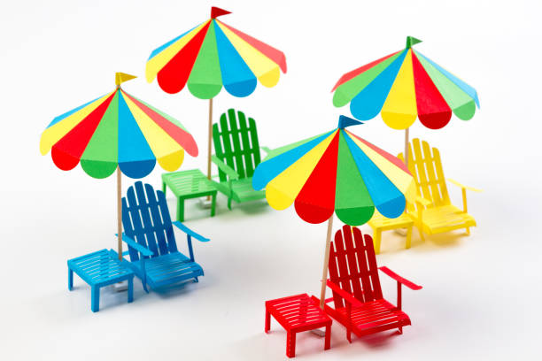istock Bright umbrellas folding chairs are made of paper on a white background 921889738