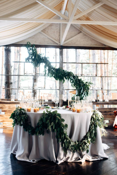 istock Decorated table for two with gold plates, candles and greens on the white tablecloth 921889930