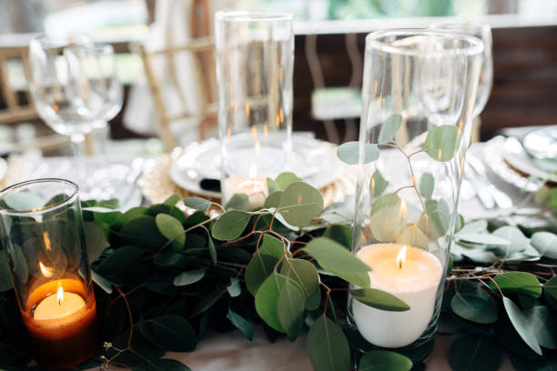 istock Decorated table with gold plates, candles and greens on the white tablecloth 921889936