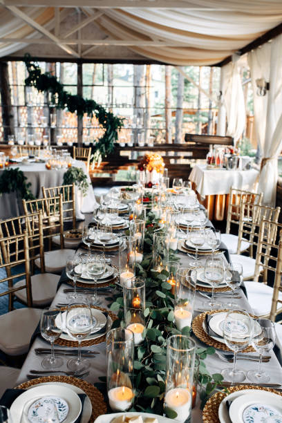 istock Decorated table with gold plates, candles and greens on the white tablecloth 921889968