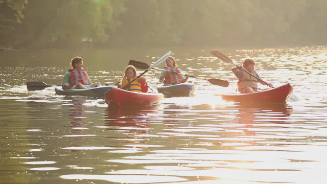 Family in kayaks on river