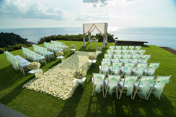 istock Wedding arch decorated with white and green flowers outdoors. Beautiful wedding set up. Wedding ceremony on green lawn in the terrace. Part of the festive decor, floral arrangement. 921893134