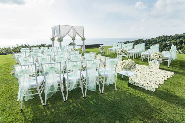 istock Wedding arch decorated with white and green flowers outdoors. Beautiful wedding set up. Wedding ceremony on green lawn in the terrace. Part of the festive decor, floral arrangement. 921893612