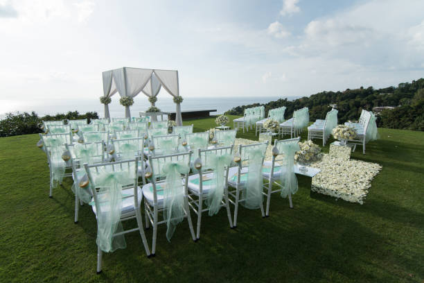 istock Wedding arch decorated with white and green flowers outdoors. Beautiful wedding set up. Wedding ceremony on green lawn in the terrace. Part of the festive decor, floral arrangement. 921893662