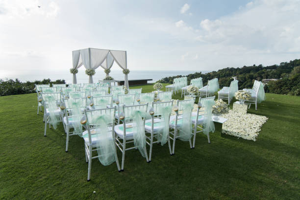 istock Wedding arch decorated with white and green flowers outdoors. Beautiful wedding set up. Wedding ceremony on green lawn in the terrace. Part of the festive decor, floral arrangement. 921893920