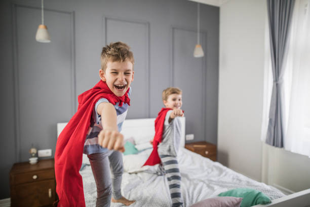 istock Joyful boys having fun while playing superheroes in a bedroom. 921894232