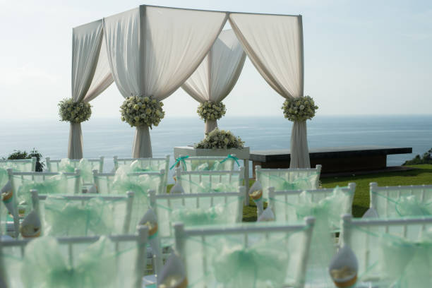 istock Wedding arch decorated with white and green flowers outdoors. Beautiful wedding set up. Wedding ceremony on green lawn in the terrace. Part of the festive decor, floral arrangement. 921894432