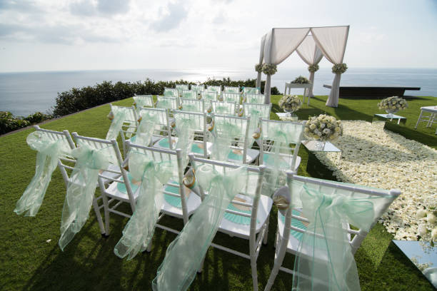 istock Wedding arch decorated with white and green flowers outdoors. Beautiful wedding set up. Wedding ceremony on green lawn in the terrace. Part of the festive decor, floral arrangement. 921894838