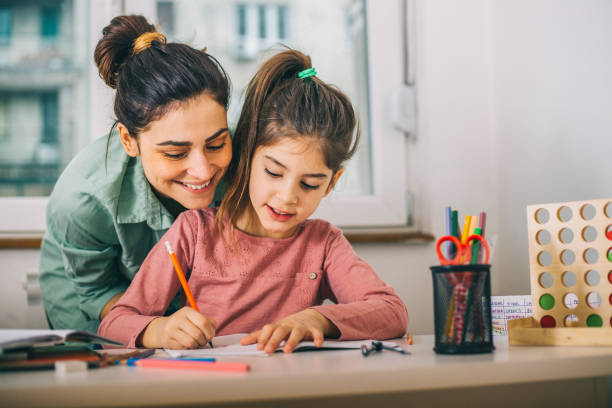 Mother Helping Her Daughter While Studying Mother Helping Her Daughter While Studying  at home one kid only stock pictures, royalty-free photos & images